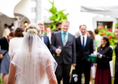 Braut bei Hochzeitsempfang mit Gaesten im Schloss Pertenstein, Chiemgau. Hochzeitsreportage und Trauung in Traunreut.