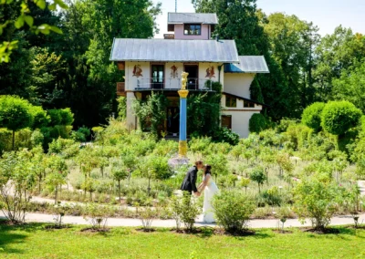 Brautpaar auf der Roseninsel im Starnberger See, romantisches Fotoshooting im Garten vor historischem Gebaeude.