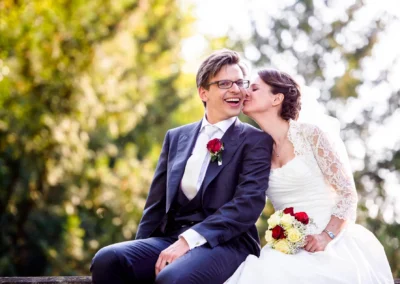 Brautpaar lacht bei einer Hochzeit im Schloss Amerang, romantische Hochzeitsreportage, festliche Aufnahme im Chiemgau.