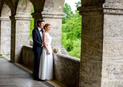 Brautpaar bei der shooting in Starnberg, unter Arkaden mit Blick ins Gruene. Hochzeitsreportage von Hochzeitsfotograf.