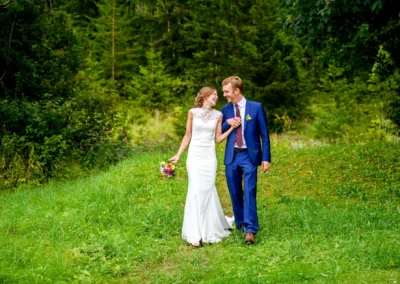 Brautpaar im Hasenoehrlhof Geitau, laechelnd im Gruenen bei der Hochzeit bei Bayrischzell.