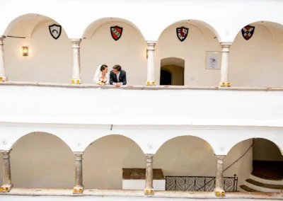 Brautpaar auf Balkon von Schloss Amerang, Hochzeitsreportage im Chiemgau, elegant und romantisch.