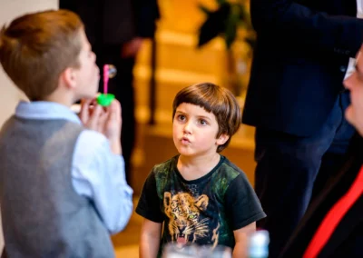Kinder bei Hochzeitsfeier in Starnberg. Junge beobachtet Seifenblasen. Hochzeitsszene, lebendig und freudig.