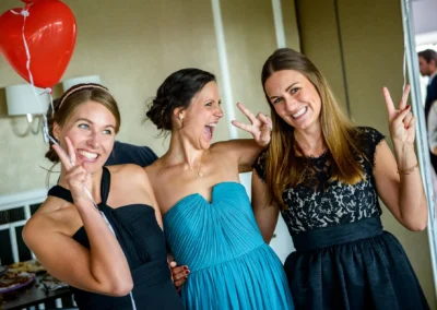 Fröhliche Hochzeitsfeier in München, drei Frauen im festlichen Kleid mit Herzballon, Trauung Reportage.