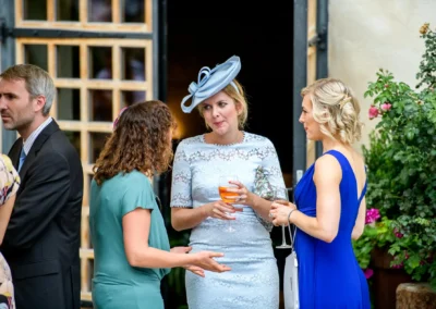Gaste bei Hochzeit im Hasenohrlhof in Geitau, Bayern, in eleganter Kleidung, entspannte Gesprache im Freien.