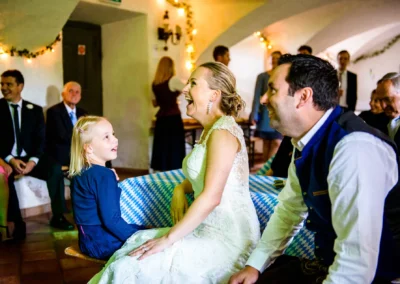 Brautpaar lacht mit Kind auf Hochzeit im Schloss Pertenstein, fröhliche Feier in Traunreut, Chiemgau Hochzeit.
