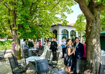 Hochzeitsfeier im Seehaus Schreyegg, Stegen am Ammersee, unter gruenen Baeumen bei sonnigem Wetter.
