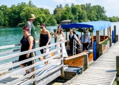 Brautpaar auf Steg der Roseninsel, Starnberger See, nach Bootsfahrt mit Hochzeitsgesellschaft.