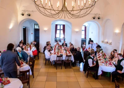 Hochzeitsgesellschaft bei festlicher Trauung im Schloss Seefeld, nahe Pilsensee, festlich gedeckte Tische.