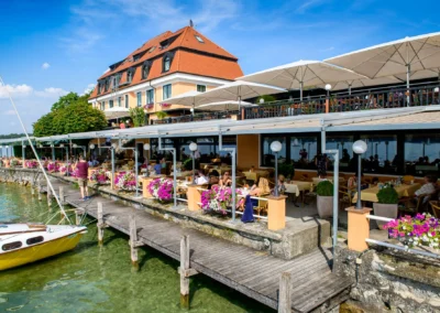 Brautpaar auf Roseninsel, Starnberger See, Hochzeitsshooting mit malerischem Blick auf Terrasse am Wasser.