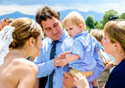 Hochzeit im Hotel Aiterbach am Chiemsee: Braut im Gespraech mit Familie. Festliche Atmosphaere.