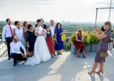 Hochzeitsfeier in München, Gruppe posiert auf Balkon. Braut in weissem Kleid, Hochzeitsreportage im Hilton Tucherpark.