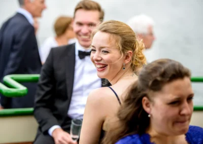 Lachende Gaeste bei einer Hochzeit im Hotel Aiterbach am Chiemsee, festliche Stimmung und elegante Kleider.