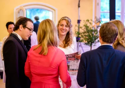 Hochzeitsgesellschaft im Schloss Aufhausen, Hochzeit in Aufhausen, Braut lacht mit Gaesten, Hochzeitsreportage.