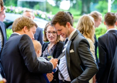 Gaste lachen bei der Hochzeit in Schloss Aufhausen, festliche Szene bei einer Hochzeitsreportage, nahe Erding.