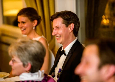 Hochzeitsempfang bei Starnberger See, glaenzende Gaeste lachen waehrend einer Hochzeitsreportage.