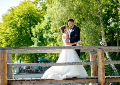 Brautpaar auf Holzbruecke bei ihrer Hochzeitsfeier in Inning am Ammersee; romantischer Moment im Seehaus Schreyegg.