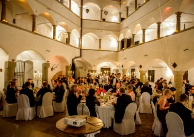 Hochzeitsfeier im Schloss Amerang mit Gaesten bei Kerzenlicht, festliche Trauung und Hochzeitsreportage im Chiemgau.