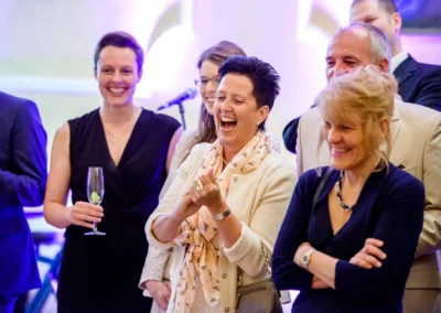 Gäste lachen bei Hochzeitsfeier im Schloss Aufhausen. Fröhliche Momente bei einer Hochzeitsreportage.