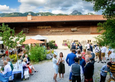 Hochzeit im Freien am Hasenoehrlhof, Gaeste feiern in Geitau bei Bayrischzell vor malerischer Kulisse.