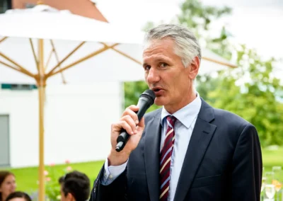 Person haelt Rede auf Hochzeit im Hotel Aiterbach am Chiemsee, elegante Umgebung und festliche Stimmung.