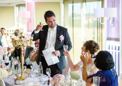 Hochzeitsfeier in Muenchen mit Brautpaar und Gaesten beim Anstossen im Hilton im Tucherpark, elegante Hochzeitsreportage.