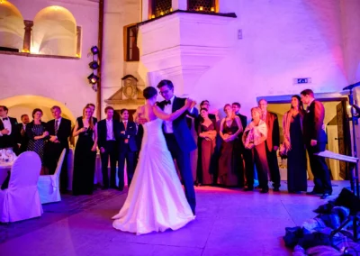 Brautpaar tanzt in Schloss Amerang, umgeben von Gästen. Hochzeitsreportage im Chiemgau.