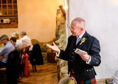 Hochzeit im Hasenoehrlhof Geitau, Redner in traditioneller Tracht spricht zur Festgesellschaft.