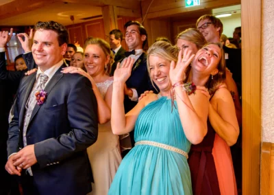 Gäste tanzen ausgelassen auf einer Hochzeit im Schloss Hohenkammer. Hochzeitsreportage von professionellem Fotografen.