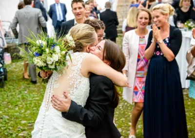 Hochzeitspaar-Umarmung bei Feier im Freien, Schloss Pertenstein. Freude und Zusammenhalt in Hochzeitsreportage.