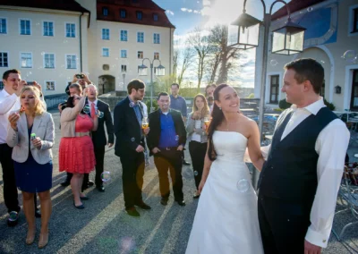 Hochzeitspaar und Gaeste bei der Trauung im Freien, Seifenblasen beim Schloss Seefeld in der Naehe des Pilsensee.