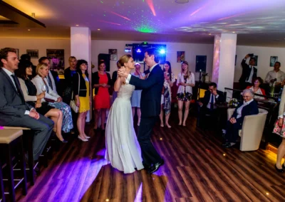 Brautpaar tanzt auf der Hochzeit in Berg am Starnberger See, umgeben von sitzenden und stehenden Gaesten.