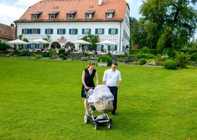 Hochzeit im Hotel Aiterbach am Chiemsee, zwei Gaeste mit Kinderwagen im Garten.