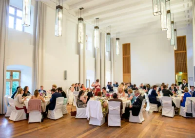 Grosse Hochzeitsgesellschaft auf Schloss Hohenkammer, elegant eingedeckt. Hochzeitsreportage im Saal.
