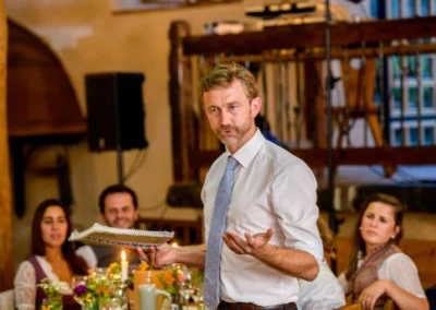 Hochzeitsansprache im Hasenoehrlhof bei Bayrischzell, Gaeste lauschen aufmerksam im rustikalen Ambiente.