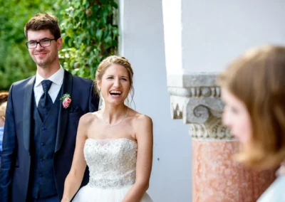 Brautpaar lacht bei Hochzeit im Hotel Aiterbach, Chiemsee. Glueckliche Momente festgehalten. Hochzeitsreportage.