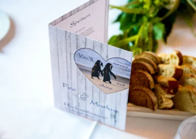 Hochzeitskarte mit Pinguinmotiv auf Tisch neben Brot, Schloss Pertenstein Trauung im Chiemgau.
