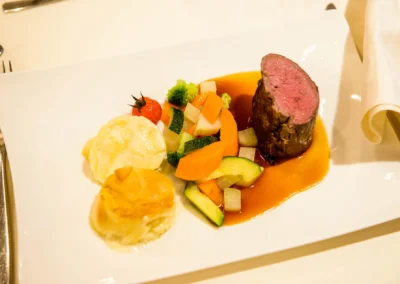 Gourmet-Hochzeitsessen mit Rinderfilet, Gemuese und Kartoffelgratin. Festlicher Hochzeitsempfang bei Schloss Hohenkammer.