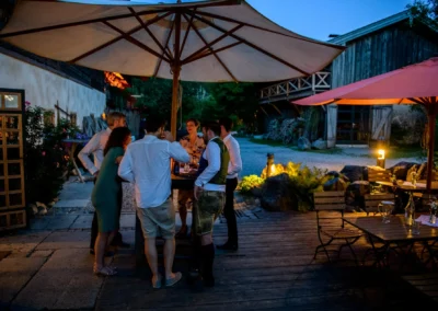 Hochzeitsfeier im Freien im Hasenoehrlhof Geitau, entspannte Atmosphaere bei Abenddaemmerung.