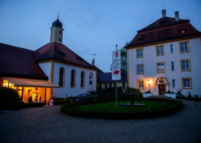Nachtaufnahme bei einer Hochzeit im Schloss Aufhausen, mit beleuchteten Fenstern und festlicher Atmosphäre.