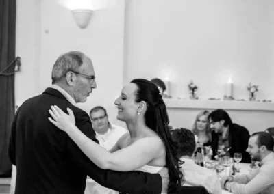 Tanz eines Paares bei einer Hochzeit im Schloss Seefeld. Gäste im Hintergrund bei der Feier in eleganter Atmosphäre.