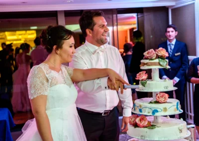 Brautpaar schneidet Hochzeitstorte bei Feier im Hilton Tucherpark, Muenchen. Hochzeitsreportage und Trauung.