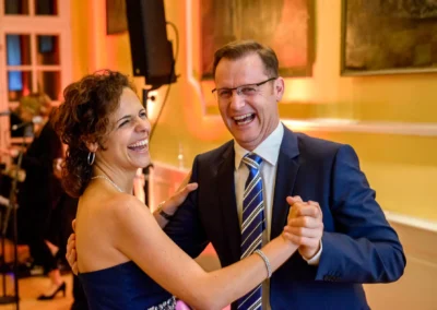 Tanzendes Hochzeitspaar bei Trauung in Schloss Aufhausen, lacht im festlichen Ambiente, Hochzeitsreportage.