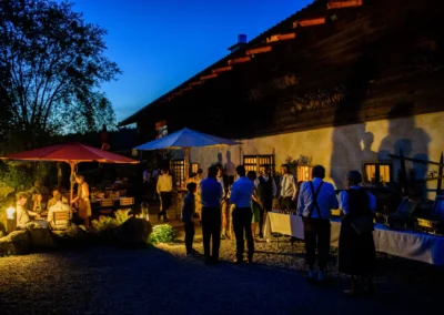 Abendliche Hochzeitsfeier im Freien im Hasenoehrlhof in Geitau mit Gaesten und Lichtern, Bayrischzell.