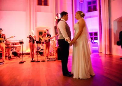 Brautpaar tanzt bei Hochzeitsfeier auf Schloss Hohenkammer, begleitet von Live-Band, Hochzeitsreportage.