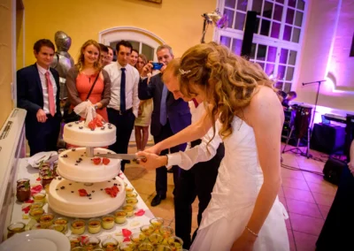 Hochzeitspaar schneidet die Torte an, von Gaesten beobachtet, Hochzeit in Schloss Aufhausen, Hochzeitsreportage.