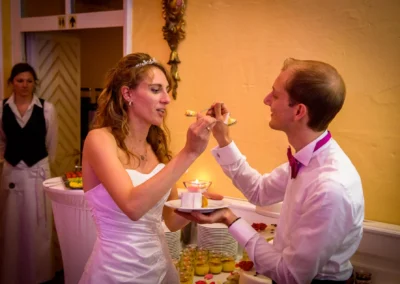 Braut und Bräutigam fuettern sich Torte bei Hochzeit im Schloss Aufhausen, Teil der Hochzeitsreportage.