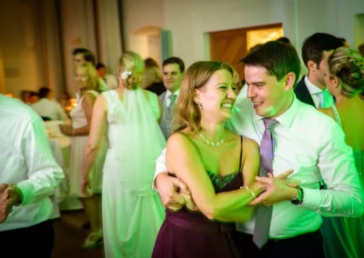 Paar tanzt laechelnd auf einer Hochzeit im Schloss Hohenkammer. Hochzeitsreportage mit festlichen Momenten.