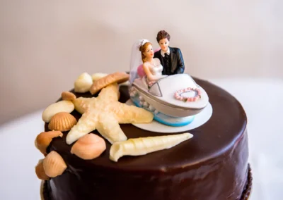 Hochzeitstorte mit Schokolade, Dekorationen und Brautpaarfigur auf einem Boot bei Schloss Pertenstein.