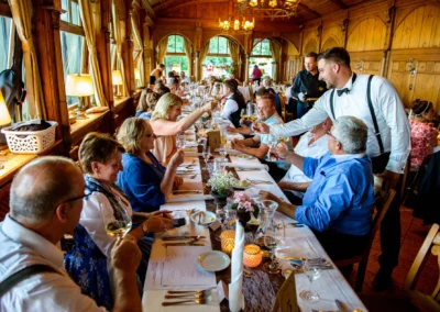 Gaste stoßen an bei einer eleganten Hochzeitsfeier im Seehaus Schreyegg, Stegen am Ammersee.